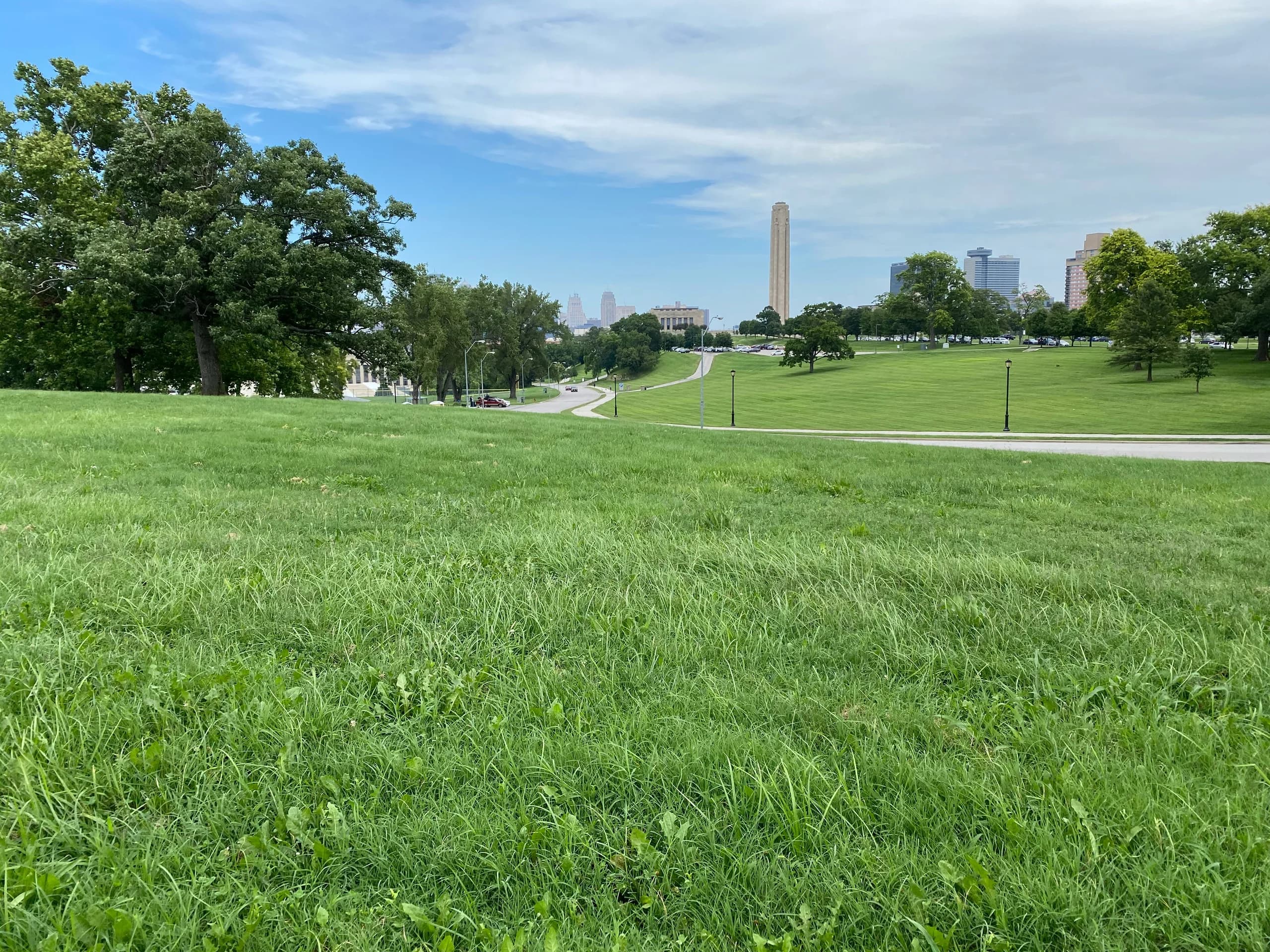 Broad green lawn with trees and the Kansas City skyline in the distance