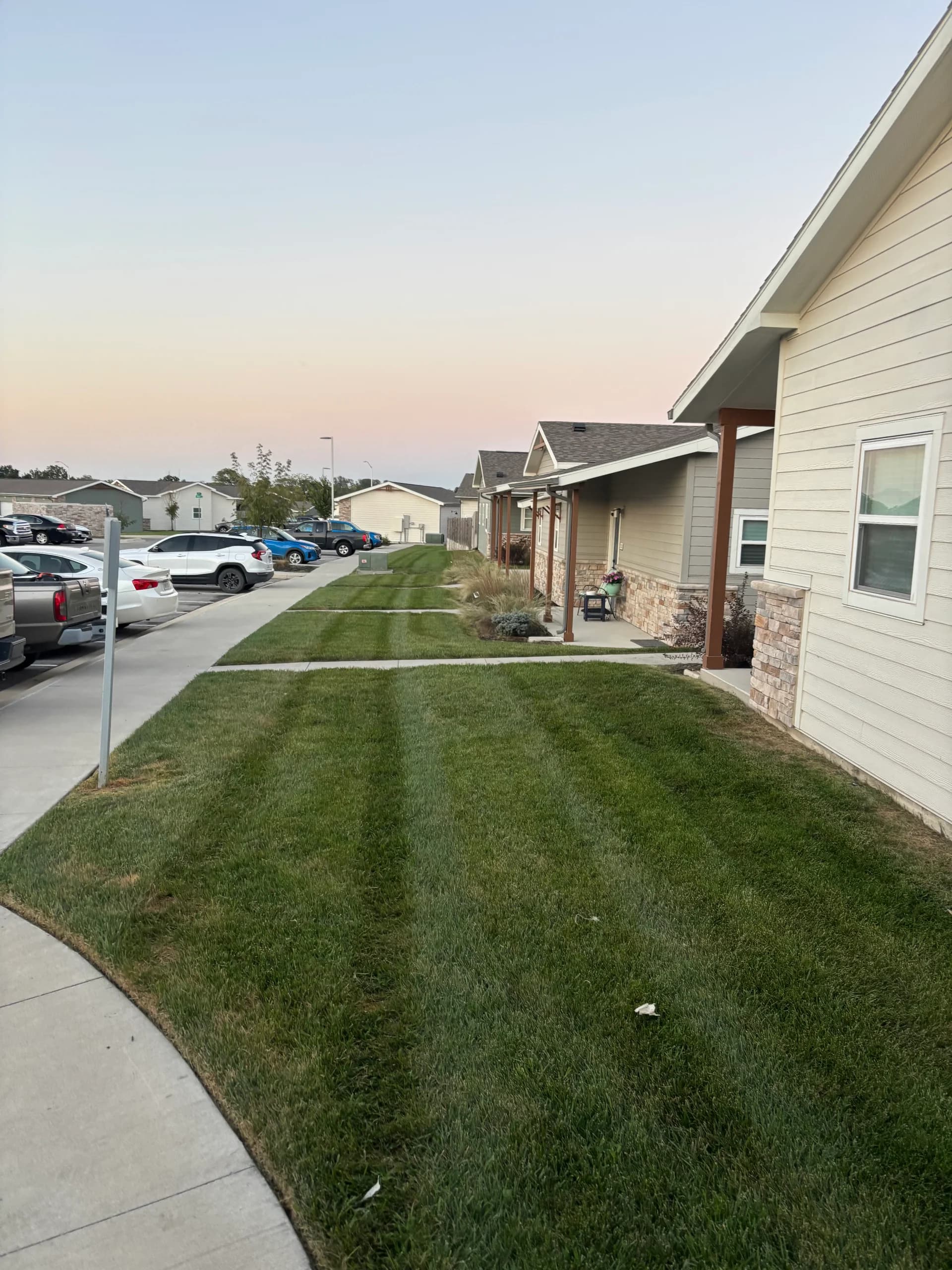 Maintained lawn between a sidewalk and homes at a multifamily property