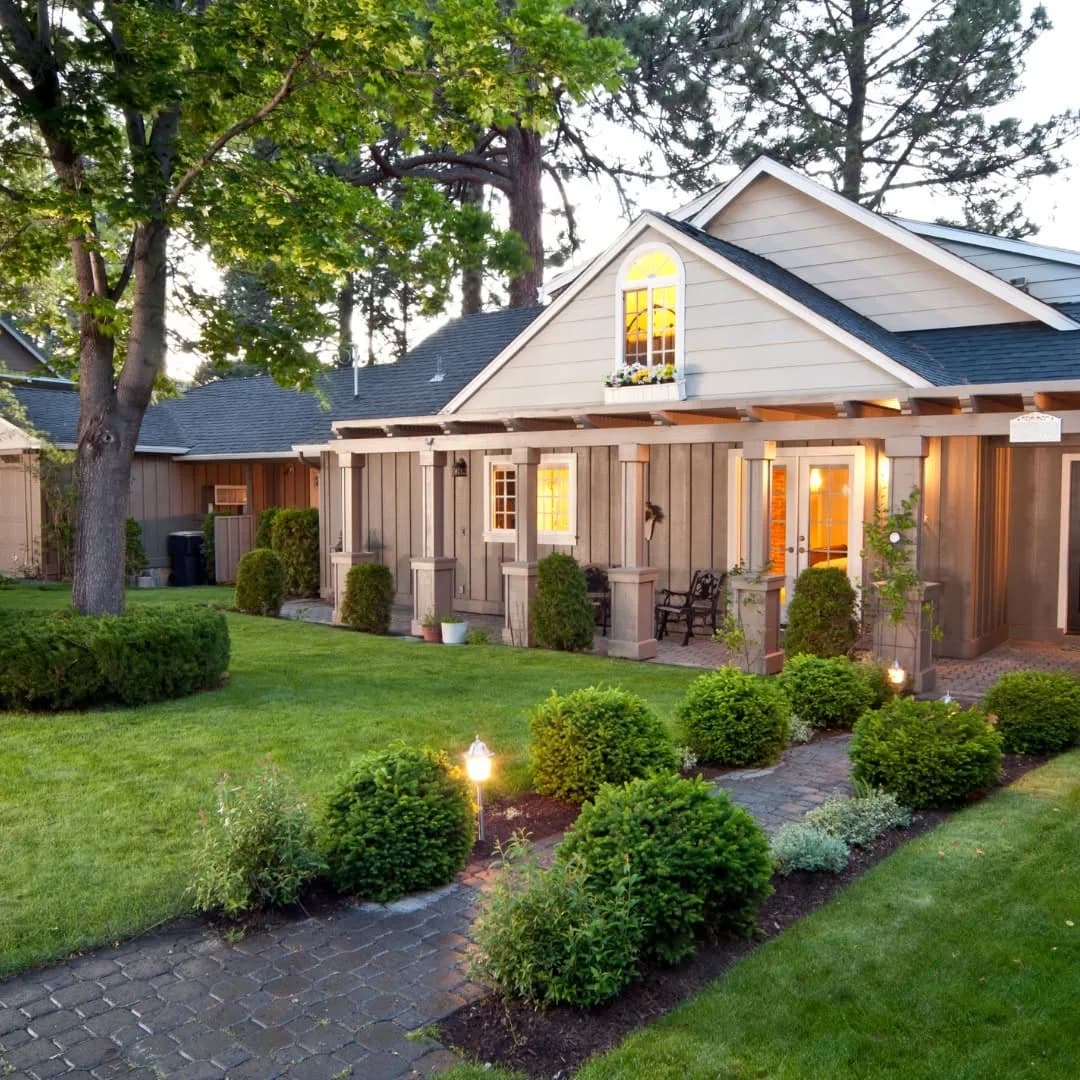 Lawn and planted beds bordering a garden path beside a residential home