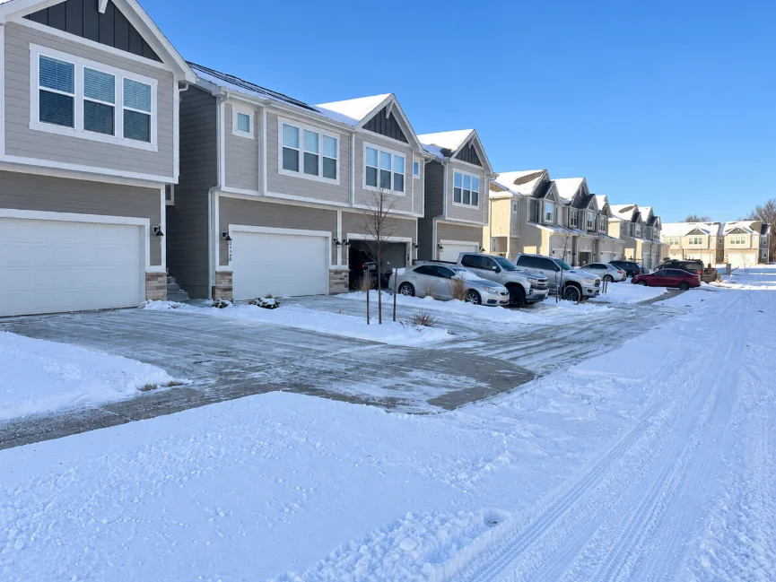 Cleared driveways beside snow-covered townhomes