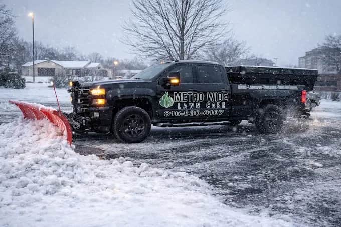 Metro Wide branded snow truck with a plow in falling snow