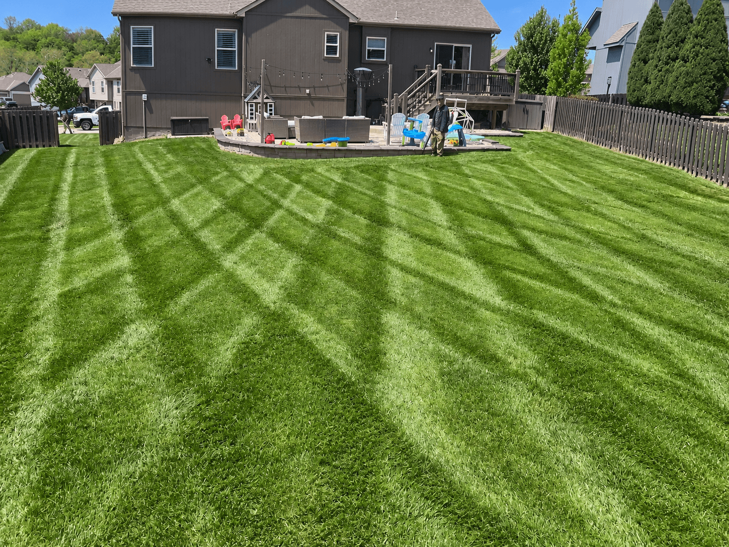 A backyard lawn with intersecting mowing stripes
